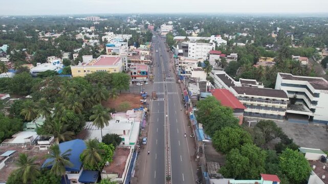 Early-morning aerial footage of Tanjore displays the outer town's hospitals, government buildings, marriage hall, School and main road. Highways and undeveloped land