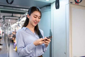 Asian woman traveler using mobile phone device while riding on the train. 