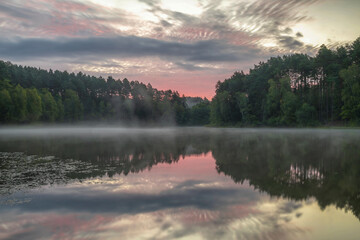 Morning over a forest lake with fog, in the Czlopa commune near Mielęcin