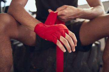 Man, boxer and wrapping knuckles with bandage for self defense, fight or workout at indoor gym. Closeup of active male person or fighter with strap on hands for boxing safety, protection or gloves