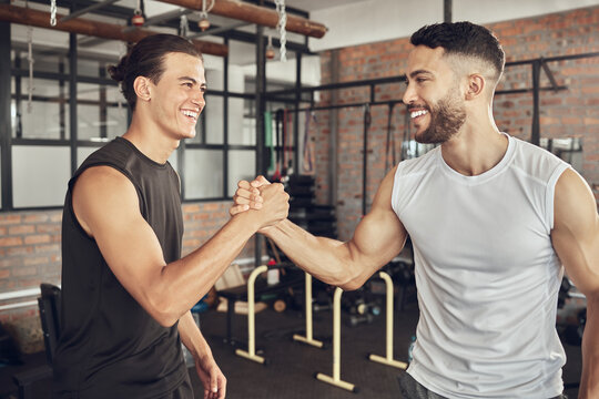 Happy man, friends and handshake with fitness partner for success, workout or teamwork together at gym. Young male person or men shaking hands with smile for training, goal or exercise at health club
