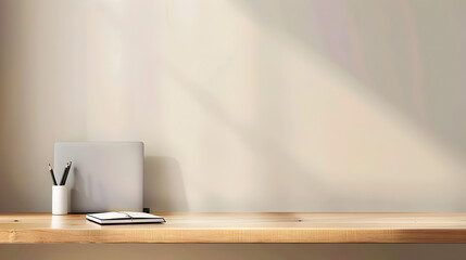 A desk with a laptop, notebook, and pen on a wooden shelf. The desk is empty and the room is bright