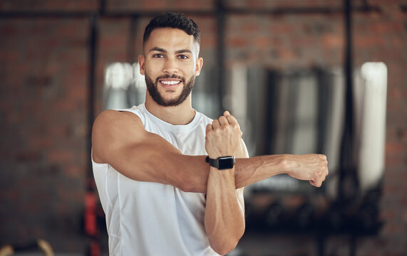 Man, portrait and stretching arm in gym for warm up, daily workout routine and fitness for muscle development. Male person, happy and flexing for physical cardio, training or exercise for health.