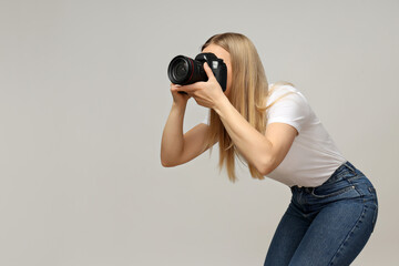 Cheerful girl photographer, on a gray background.