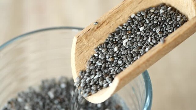 pouring chia seeds from a wooden spoon 