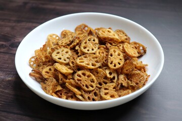 Crispy lotus stem chips, perfectly spiced and golden brown, offer a delightful crunch and unique flavor. Ideal for snacking or as a gourmet appetizer. kurkuri Kamal kakdi. copy space.