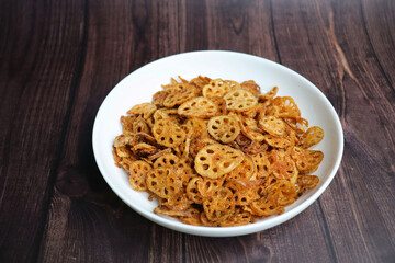 Crispy lotus stem chips, perfectly spiced and golden brown, offer a delightful crunch and unique flavor. Ideal for snacking or as a gourmet appetizer. kurkuri Kamal kakdi. copy space.