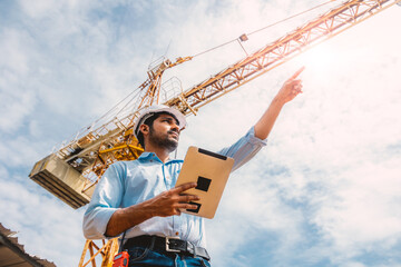 Indian construction engineer worker construction site control operation. Foreman operate tower...