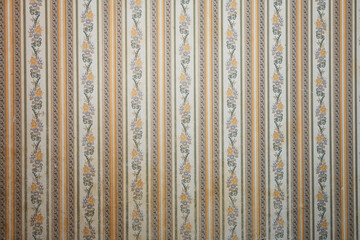 Old wallpaper on the wall. Old wallpaper for texture or background.