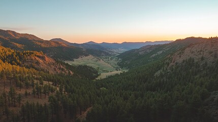 Fototapeta premium Overhead shot of a mountain valley at sunrise, with clear sky for copy