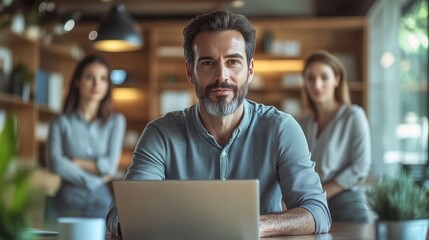 Fototapeta premium A man discusses a project while seated at a laptop in an office