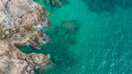 Rocky coastline cliffs, sea water surface aerial view with copy space.