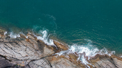 Rocky coastline cliffs, sea water surface aerial view with copy space.