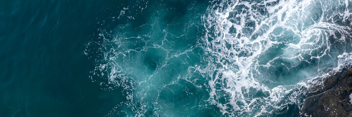 Abstract of sea foam in the dark turquoise ocean.