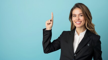 Portrait of happy smiling beautiful young woman pointing finger up, copy space.