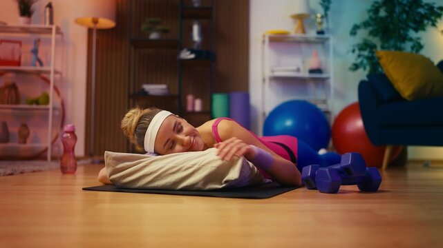 Funny woman in activewear sleeping on yoga mat instead of training, laziness