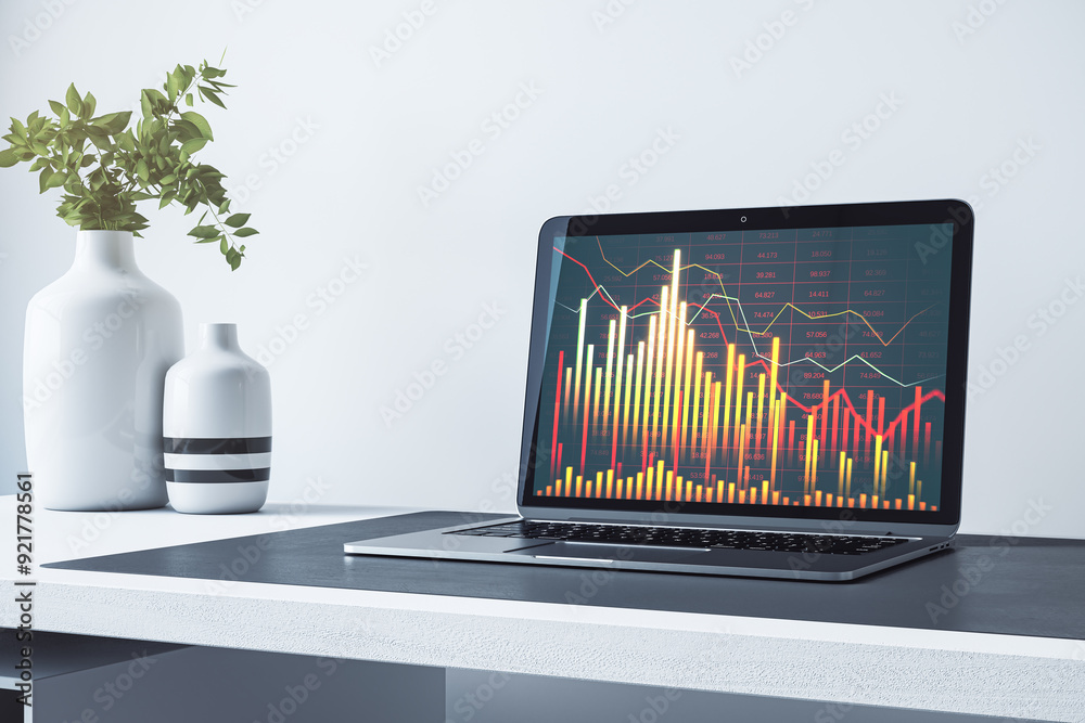 Poster close up of laptop on desk with plants in vase and downward forex chart on white wall background. fi