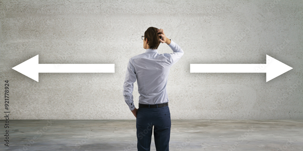Poster Back view of thoughtful young businessman with two pointers on concrete background, deciding which way to go. Decision and way concept.
