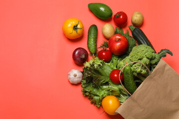 Delivery of vegetarian products. Bag with different vegetables and fruits on red background, top view