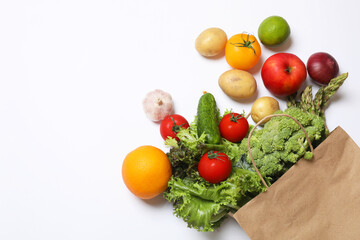 Delivery of vegetarian products. Bag with different vegetables and fruits on white background, top view