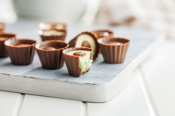 Sweet pralines. Chocolate truffles on cutting board on white table.