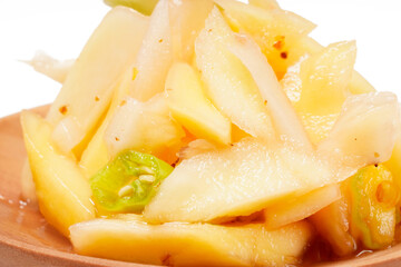 Mango sambal made from shredded young sour mango, mixed with chili, sugar, and spices. A blend of spicy, sweet, and tangy flavors. Photographed on a white background.