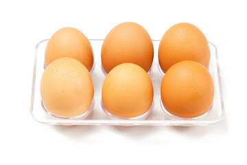 A row of light brown chicken eggs placed in a transparent holder, typically stored in the fridge. Photographed against a white background.