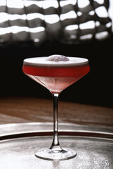 Cocktail in a martini glass on a dark background.