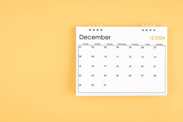 December 2024 desk calendar on yellow color background, position with copy space.