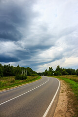 Menacing rain clouds moving towards the highway, landscape before the downpour