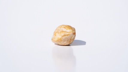 Minimalist Display of Candlenut Seeds Against a Bright White Background with Strong, Sharp Shadows