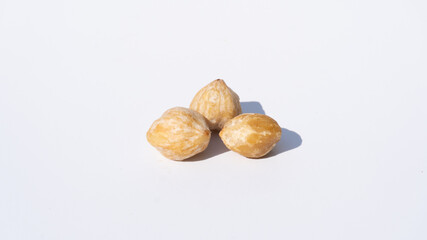 Candlenut Seeds in a Minimalist Composition, Resting on a White Background with Visible Shadows