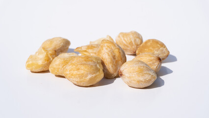 Close-Up of Candlenut Seeds on a White Background, Highlighting Their Natural Rough Texture