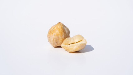 Earthy Candlenut Seeds on a White Background, With Natural Light Enhancing Their Texture and Shadows