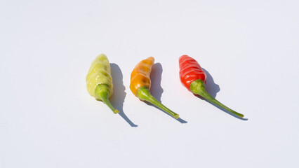 Red, Yellow, and Green Chilies on White: A Simple Display