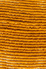 Abstract orange background of spilled turmeric powder, top view