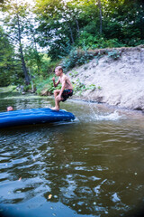Fototapeta premium a boy bathes in a river in the summer on a hot day 