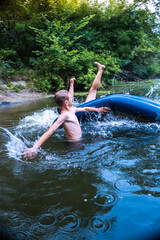 Fototapeta premium a boy bathes in a river in the summer on a hot day 