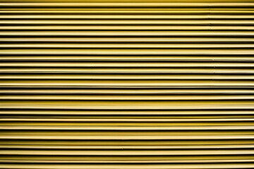 Obraz premium Yellow store front metal iron curtain texture background. Roll up metal blinds background.