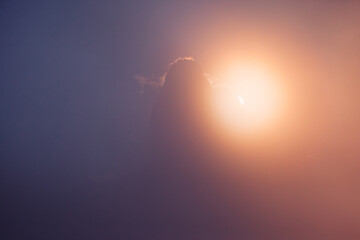 The sun peeks out from behind the sharp peak of the rock. National Park Tre Cime di Lavaredo, Dolomiti alp.