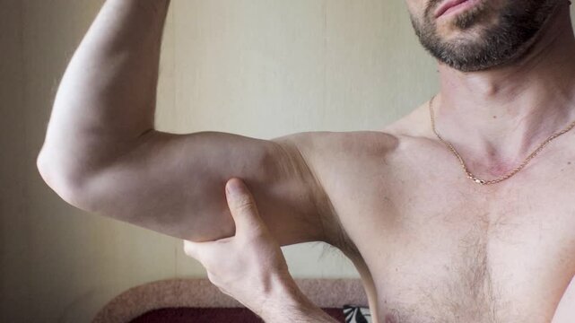 A man shows off the biceps of his arms.