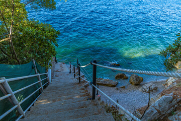 Dangerous descent down steep stairs to a small beach