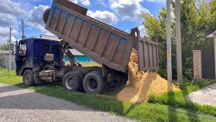 A truck brought sand for the construction site. Bulk cargo delivery