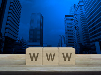 WWW letter on wood block cubes on wooden table over modern office city tower and skyscraper, Searching system and internet concept