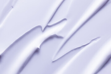 Cosmetic cream texture background. Light purple lotion, moisturizer, face mask smeared. Creamy skincare product closeup