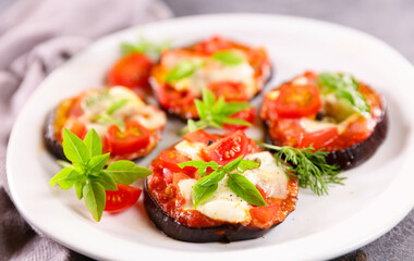 baked eggplant slices with tomato sauce, mozzarella and basil