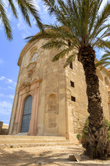 Obraz premium Ancient Mediterranean church with palm tree
