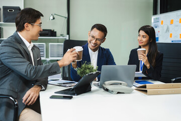 colleague business people descent holds a cup of coffee and talking discussion ideas and happily.
