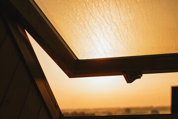 Dewy window view with sunrise in the background