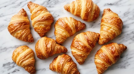Delicious croissants with a flaky texture and golden color arranged on a marble surface. Ideal for breakfast and bakery imagery